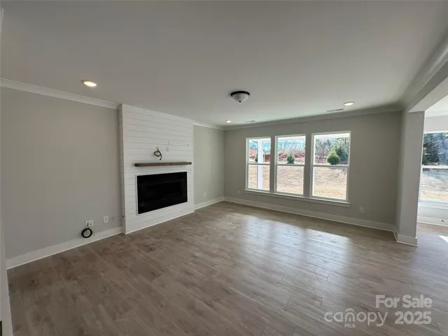 an empty room with wooden floor and fireplace