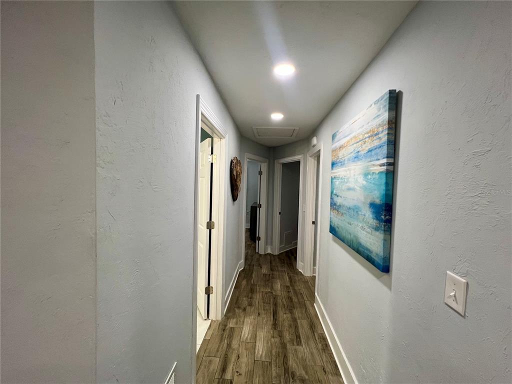 112 Rose Street Venice, FL 34293 - Photo 12 of 33 a view of a hallway with wooden floor and a bathroom