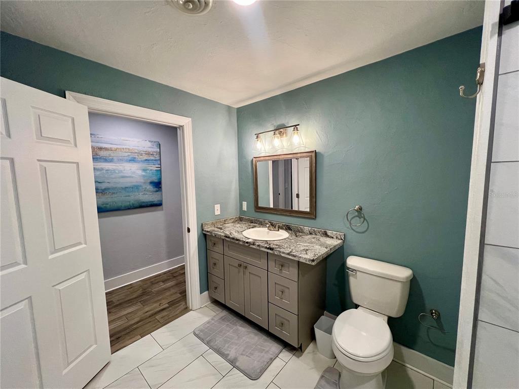 112 Rose Street Venice, FL 34293 - Photo 14 of 33 a bathroom with a granite countertop toilet sink and mirror