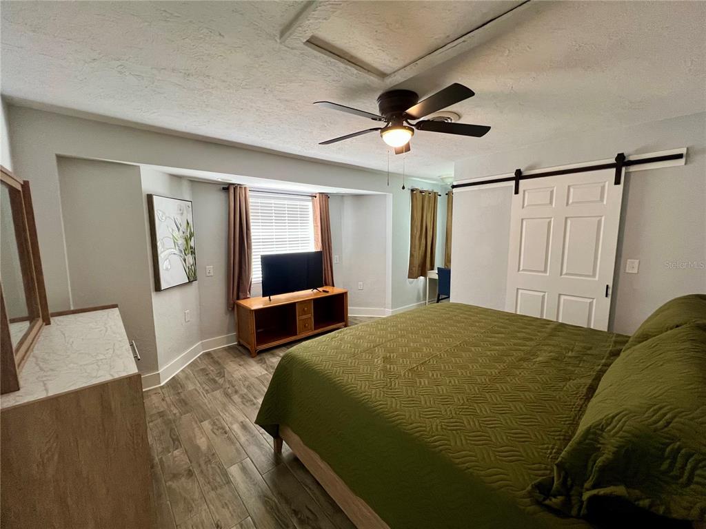 112 Rose Street Venice, FL 34293 - Photo 16 of 33 a bedroom with a bed dresser and a flat tv screen