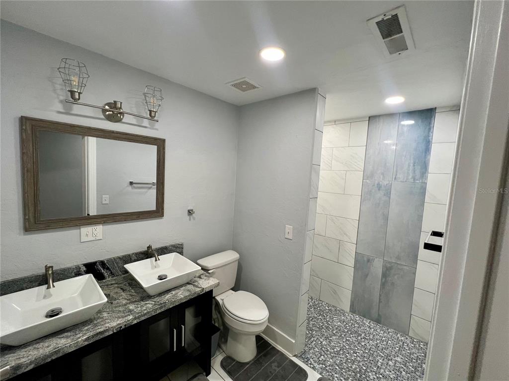 112 Rose Street Venice, FL 34293 - Photo 21 of 33 a bathroom with a granite countertop sink toilet and shower