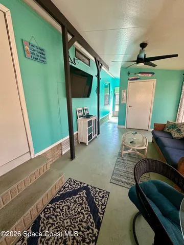 a living room with a rug and a floor to ceiling window