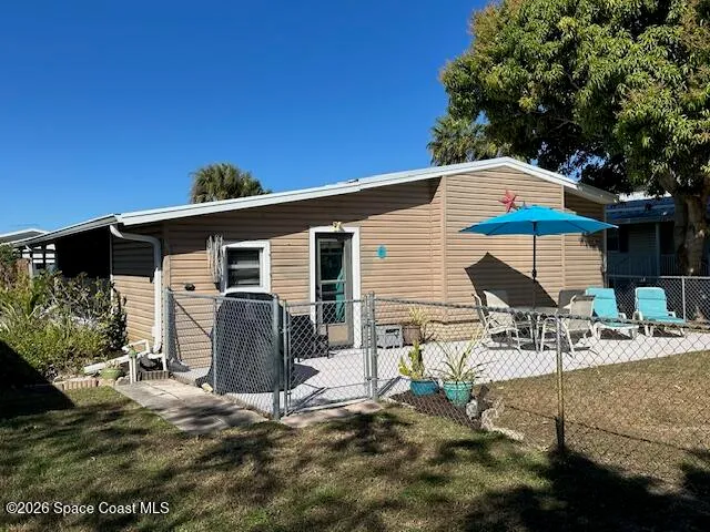 a view of house with backyard and sitting area