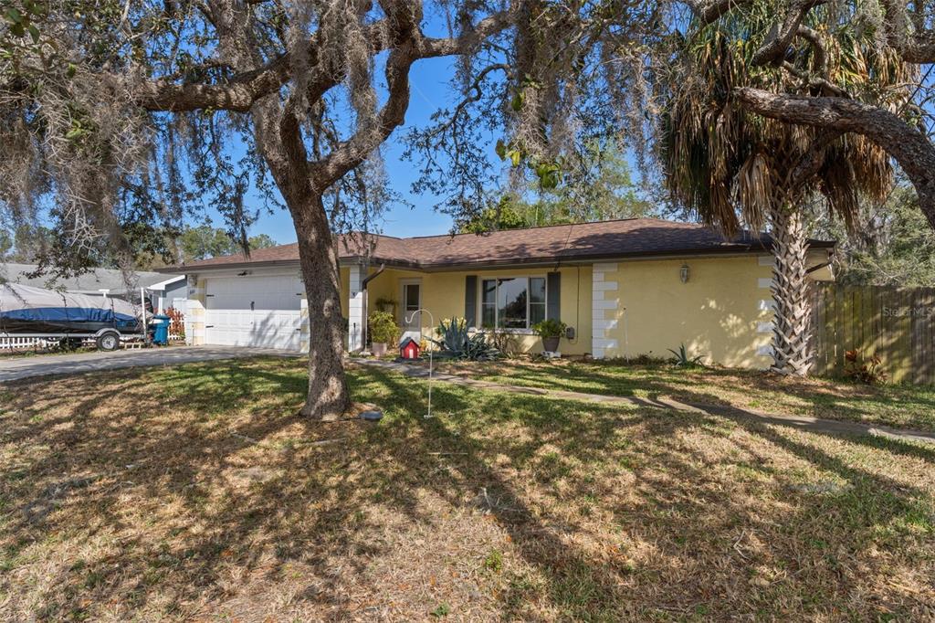 6101 County Line Road Spring Hill, FL 34606 - Photo 5 of 40 a front view of a house with a garden