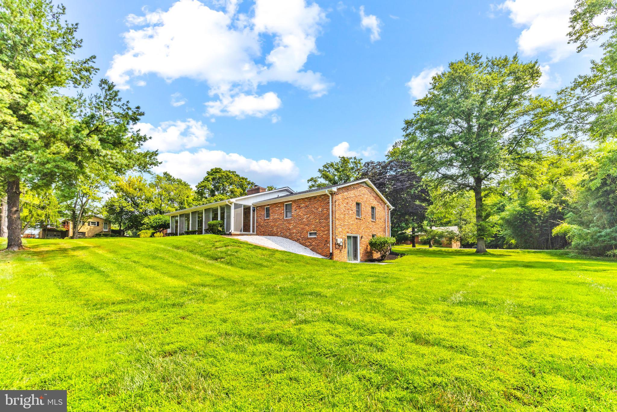 4218 Southfield Road Ellicott City, MD 21042 - Photo 54 of 59 a yellow house with a big yard and large trees