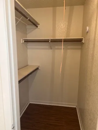 a view of walk in closet with empty racks