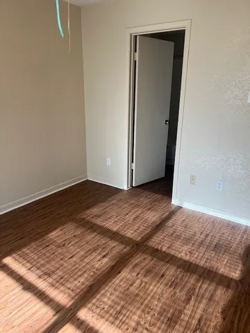 a view of a room with wooden floor and white wall