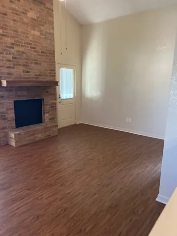 an empty room with wooden floor and fireplace