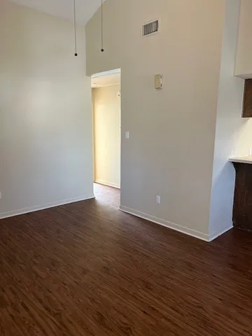 a view of an empty room with wooden floor