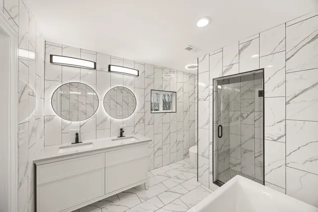 a bathroom with a double vanity sink mirror toilet and shower