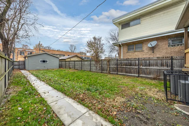 a view of a house with a yard and a wooden fence
