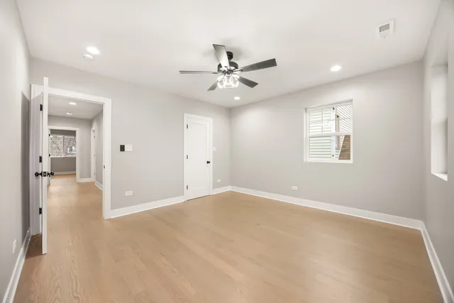 an empty room with fan and windows