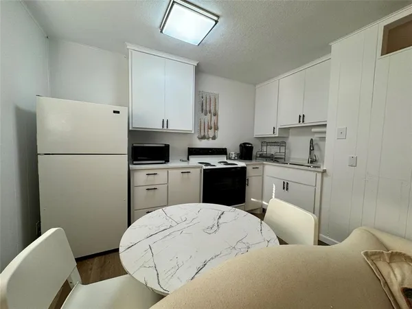 a kitchen with white cabinets and stainless steel appliances