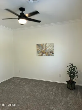 an empty room with a ceiling fan and window