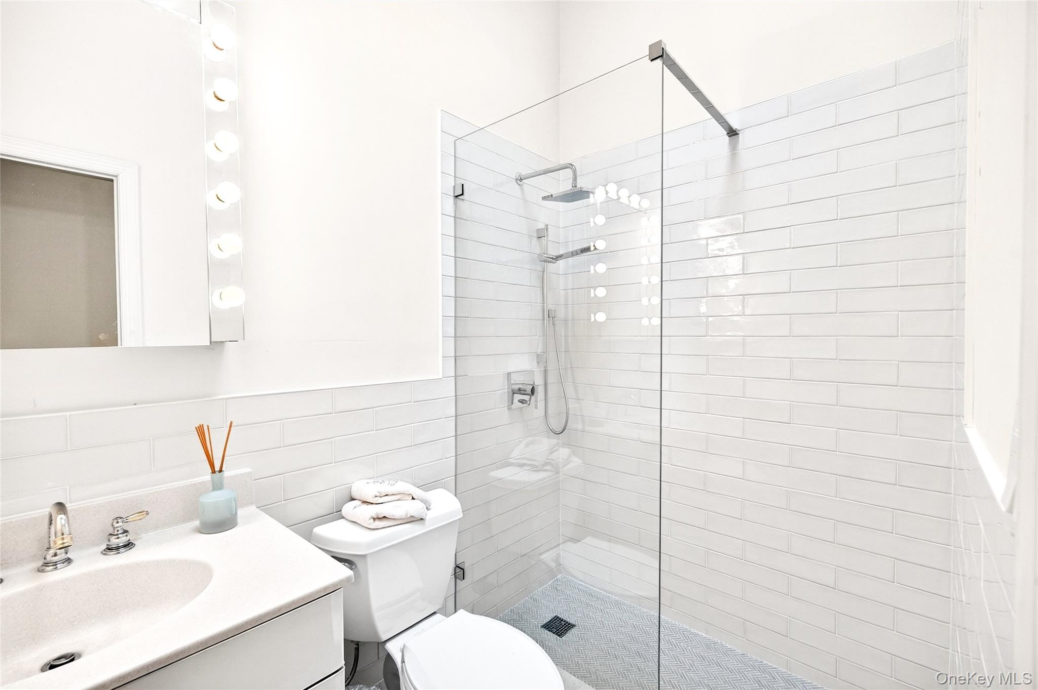 3334 Country Club Road Bronx, NY 10465 - Photo 28 of 49 Bathroom with walk in shower, vanity, decorative backsplash, and tile walls