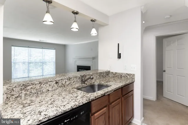 a kitchen with a sink granite counter tops and a window