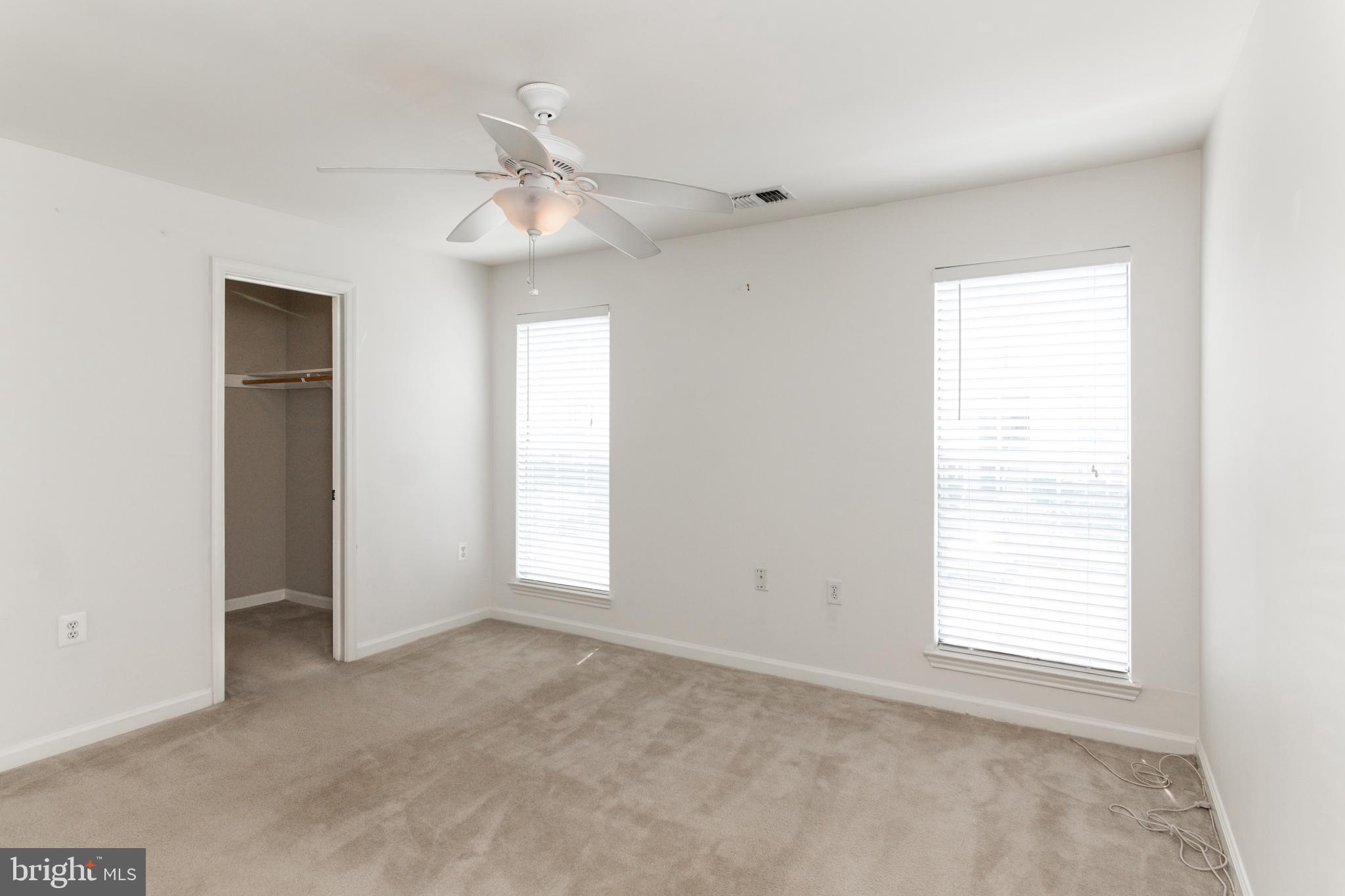 20958 Timber Ridge Terrace, Unit 201 Ashburn, VA 20147 - Photo 19 of 25 an empty room with windows and fan