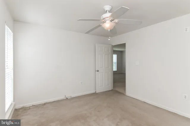 an empty room with a ceiling fan and a bathroom