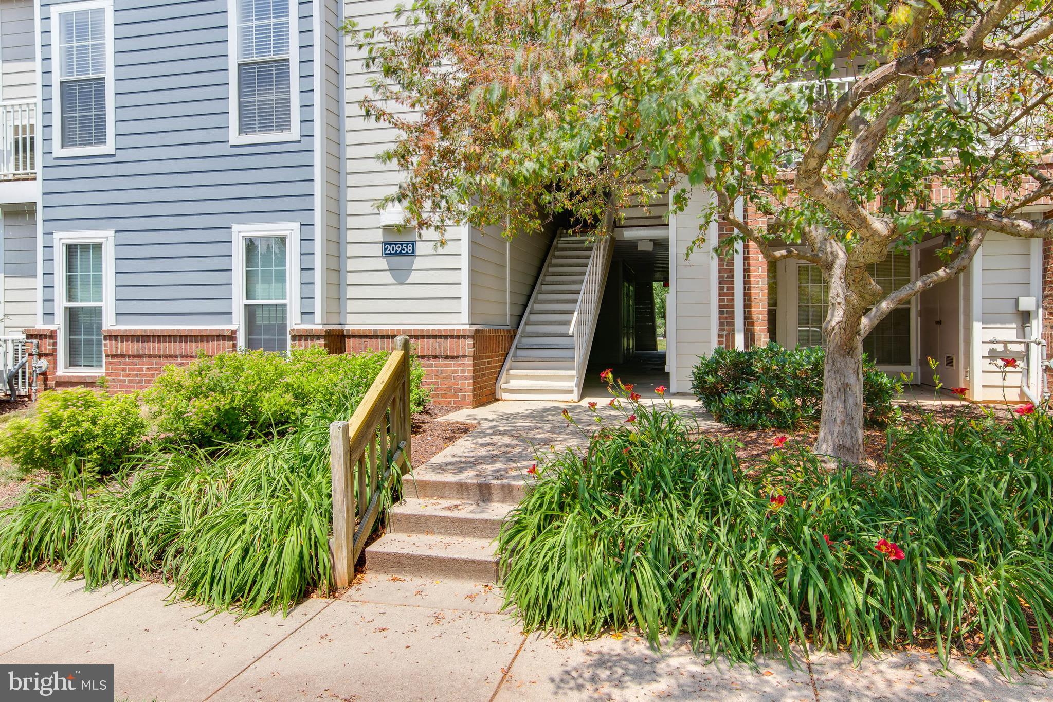 20958 Timber Ridge Terrace, Unit 201 Ashburn, VA 20147 - Photo 4 of 25 a front view of a house with garden