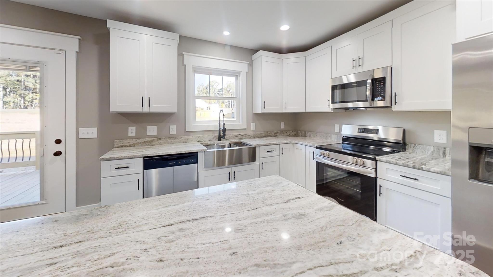 268 Vic Randall Road Lawndale, NC 28090 - Photo 14 of 22 a kitchen with stainless steel appliances granite countertop a stove top oven a sink dishwasher and a refrigerator with wooden floor