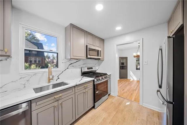 a kitchen with stainless steel appliances granite countertop a refrigerator and a sink