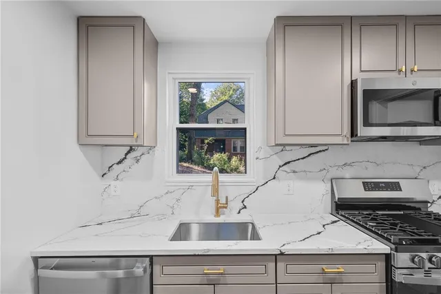 a kitchen with a sink and a stove with cabinets