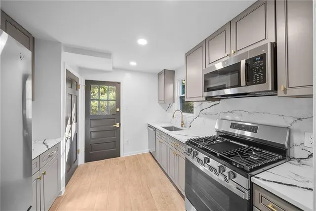 a kitchen with stainless steel appliances granite countertop a stove microwave and refrigerator