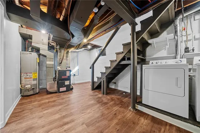 a view of an empty room with wooden floor and furniture