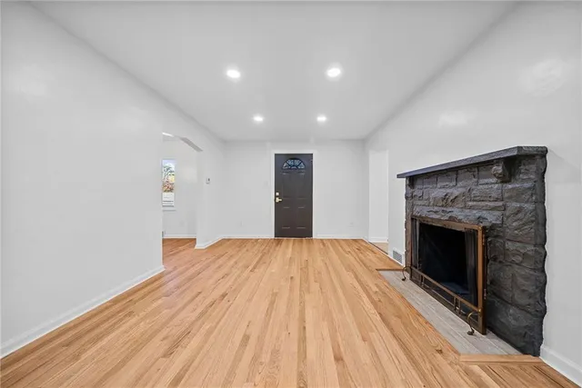 a view of empty room with wooden floor and fireplace