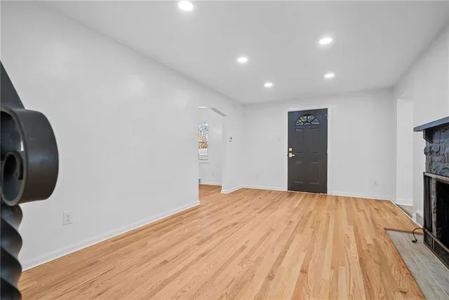 a view of a livingroom with wooden floor and a bathroom