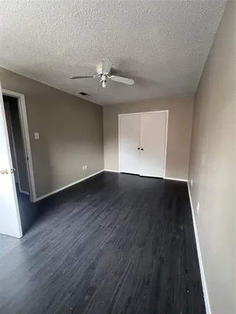 an empty room with wooden floor and ceiling fan