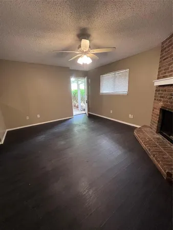 a view of an empty room with window and fireplace