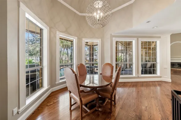 an empty room with a chandelier fan and windows
