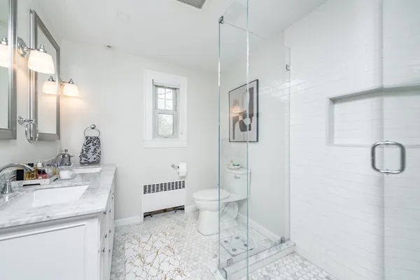 a bathroom with a granite countertop sink a toilet and a mirror