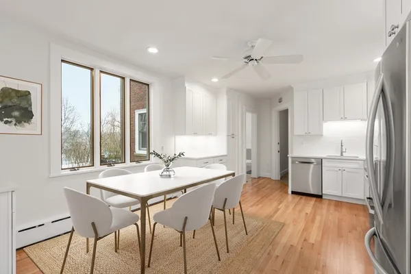 a kitchen with a table chairs refrigerator and cabinets