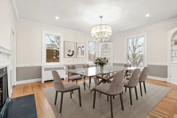 a view of a dining room with furniture a chandelier and wooden floor