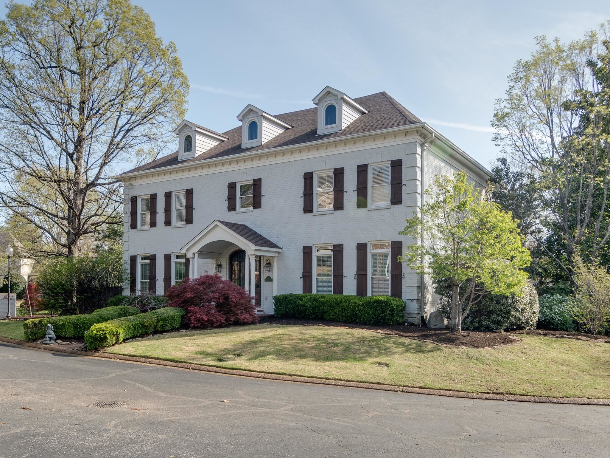 a front view of a house with a garden