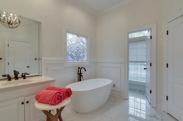 a bathroom with a bathtub sink and mirror