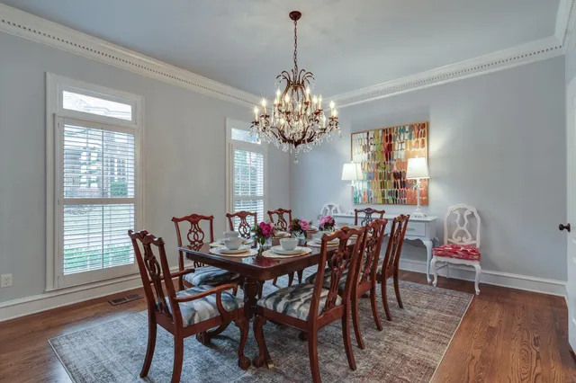 a dining room with furniture a chandelier and wooden floor
