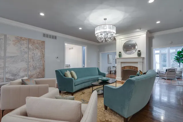 a living room with furniture a fireplace and chandelier