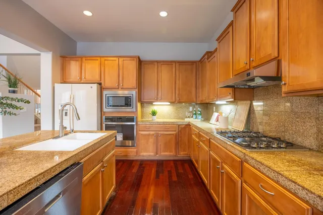 a kitchen with stainless steel appliances granite countertop a sink and cabinets