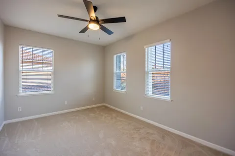 a view of a house with a small yard and large tree