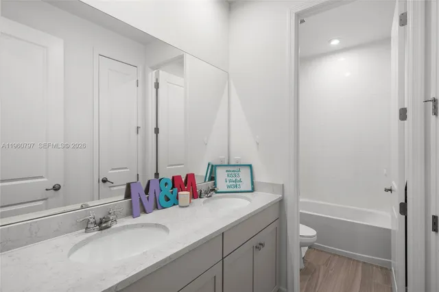 a bathroom with a granite countertop sink a toilet and shower
