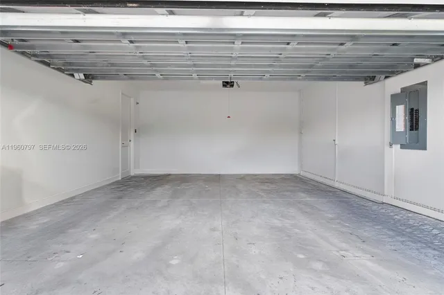 a view of a white house with a big yard and potted plants