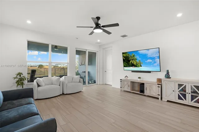 a living room with furniture and a dining table with wooden floor