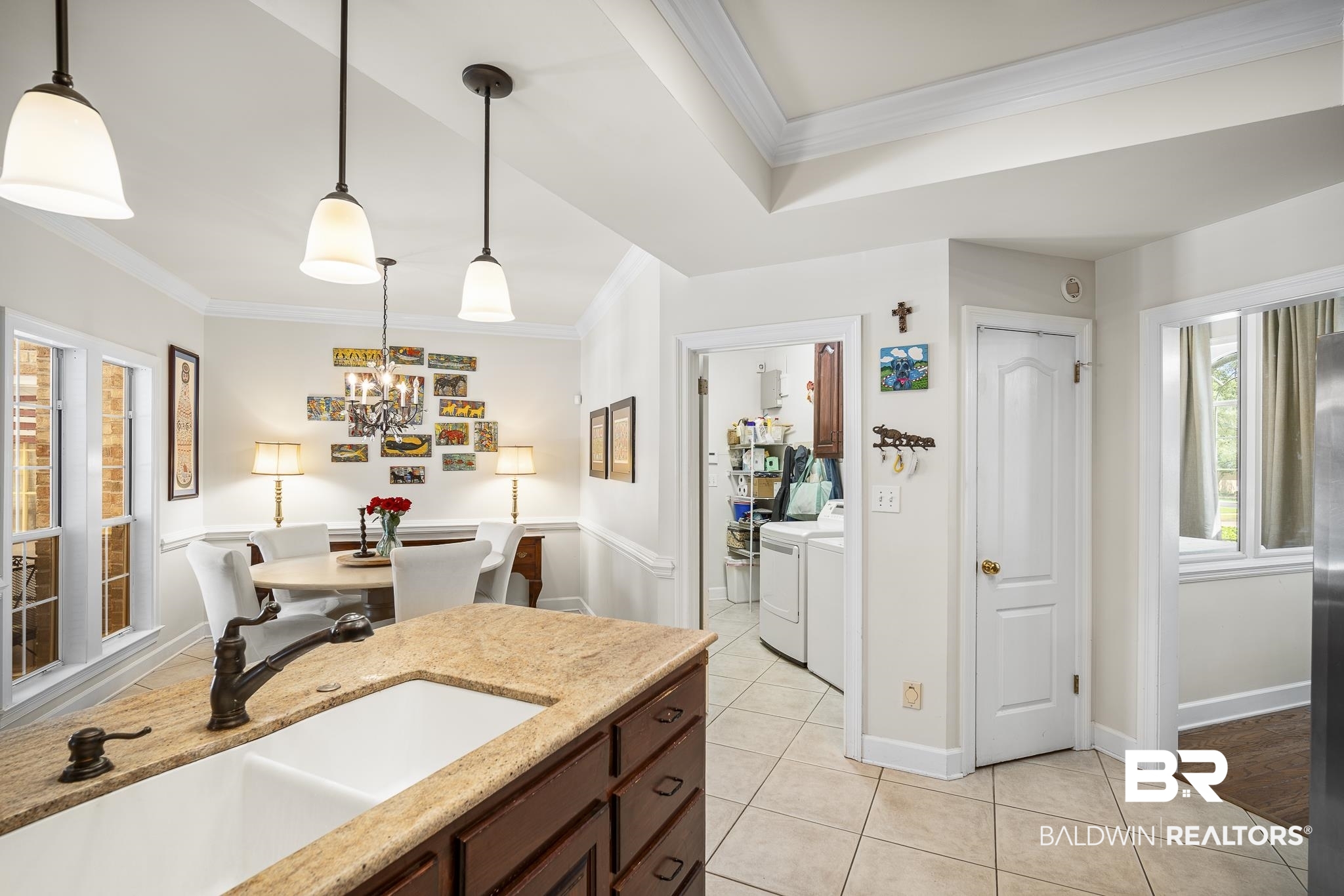 402 Potters Mills Road Daphne, AL 36526 - Photo 13 of 45 Kitchen with washing machine and clothes dryer, a sink, ornamental molding, light tile patterned floors, and a chandelier