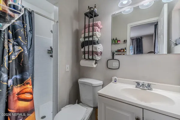 a bathroom with a toilet sink vanity and mirror