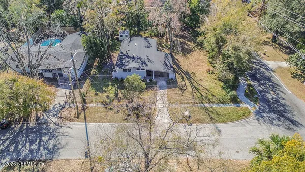 a aerial view of a house with a yard and large trees