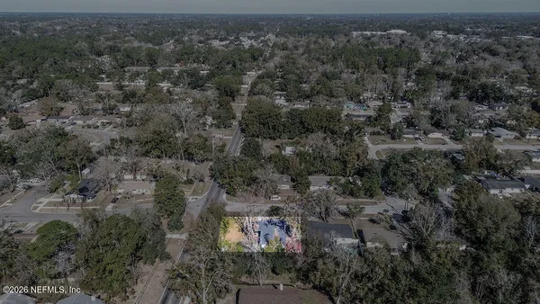an aerial view of residential house with outdoor space and trees all around