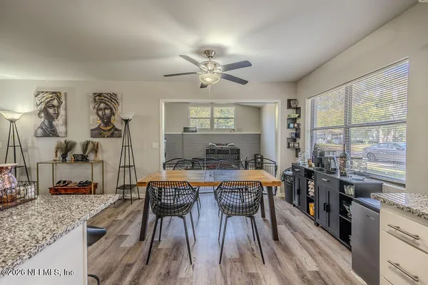 a kitchen with stainless steel appliances granite countertop a stove a sink dishwasher a dining table and chairs with wooden floor